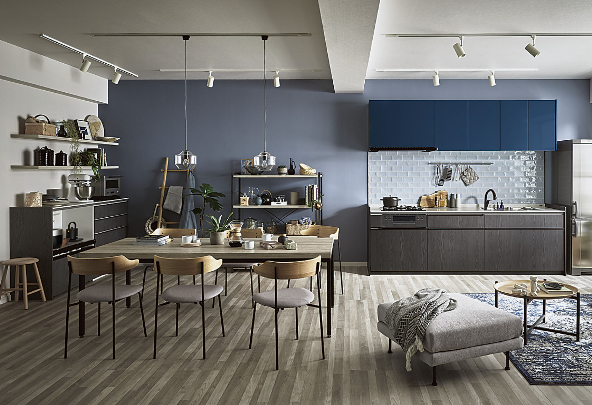 ペンダントライトとスポット照明で照らされた、モダンテイストなダイニングキッチン